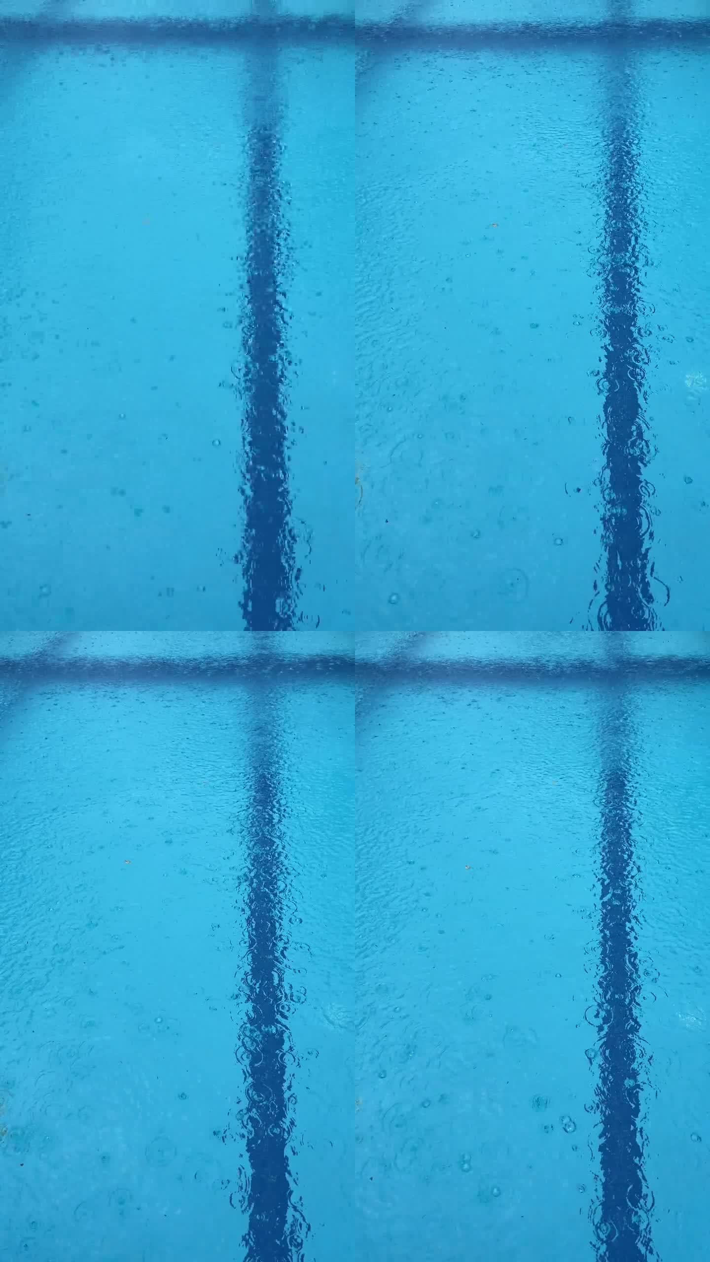 大雨打在泳池表面。雨滴在水面上产生气泡