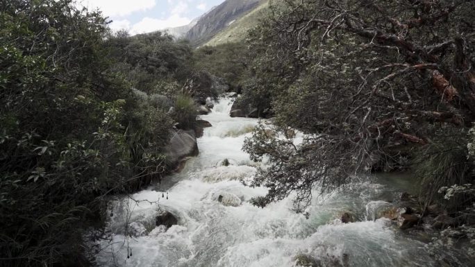 在通往位于秘鲁偏远安第斯山脉的高海拔白山山脉的拉古纳帕隆湖的路上，一条生机勃勃的河流。