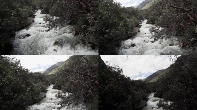 在通往位于秘鲁偏远安第斯山脉的高海拔白山山脉的拉古纳帕隆湖的路上，一条生机勃勃的河流。