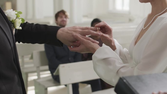 教堂婚礼上，新娘把戒指戴在新郎手指上