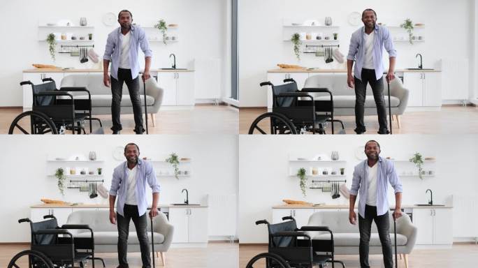 非洲残疾男子从轮椅上站起来时拄着拐杖
