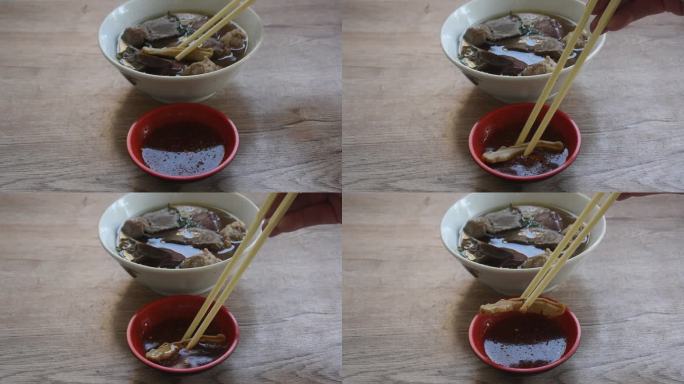 煮熟的猪血和猪内脏用剁碎的猪肉在汤里用筷子夹蘸辣椒酱