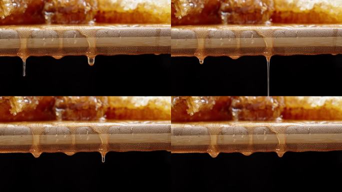 天然蜂蜜在一块木板上的蜂巢，从上面滴下蜂蜜。多莉滑块极端特写。