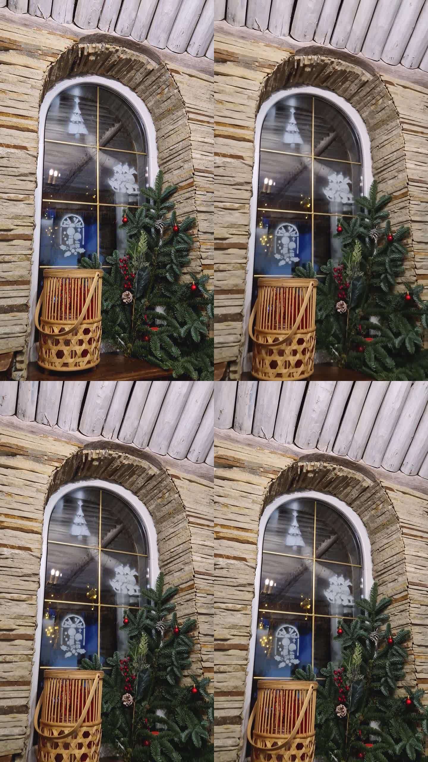 冷杉树枝作为圣诞节的装饰品挂在窗台上，在质朴的房子的玻璃上画上冬季节日的标志