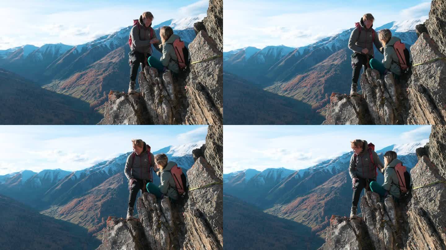 登山者爬上山谷上方陡峭的山脊