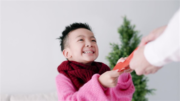 快乐的亚洲小男孩收到红包，庆祝中国新年