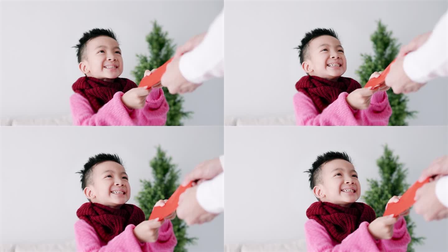 快乐的亚洲小男孩收到红包，庆祝中国新年