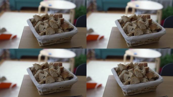 一堆面包放在桌子角落的篮子里，准备做奶酪火锅，这是瑞士传统的鱼食材