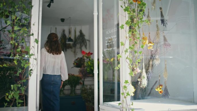 女企业家开花店。自信的女孩老板在花店工作。