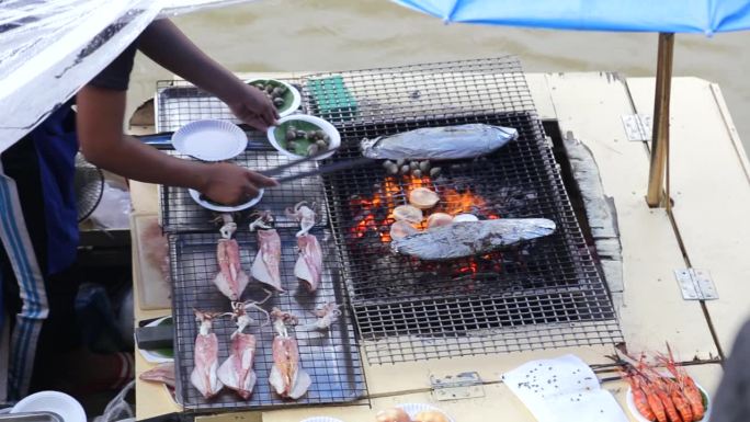 泰国安帕瓦水上市场的船商烤制海鲜