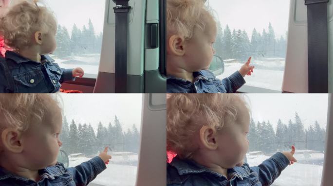 宝宝看着窗外下雪的天气和森林