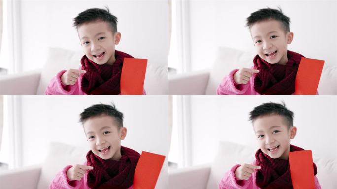 快乐的亚洲男孩展示并拿着红包。快乐的中国新年概念。