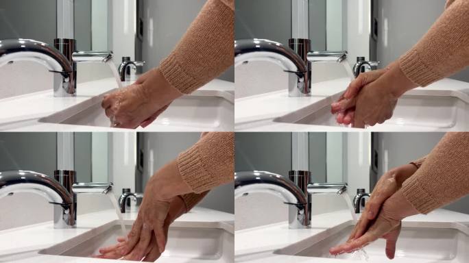 女人在自来水下洗手上的肥皂泡沫。在浴室洗手。