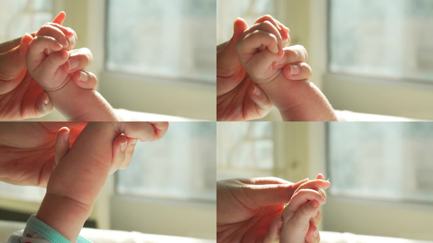 日出时新生儿握着母亲手指的特写