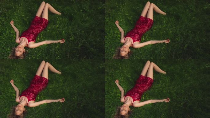 年轻美丽的女人躺在草地上