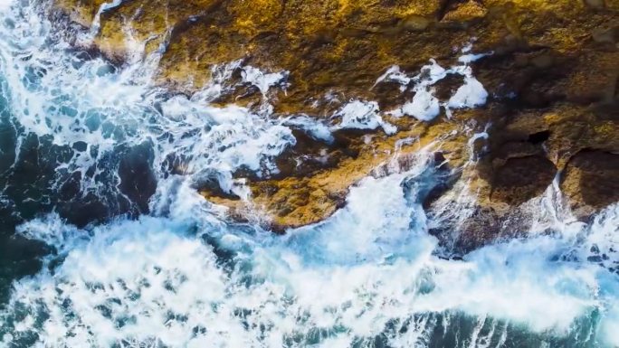 从空中俯瞰海浪撞击岩石的画面。海浪冲击着岩石峭壁。