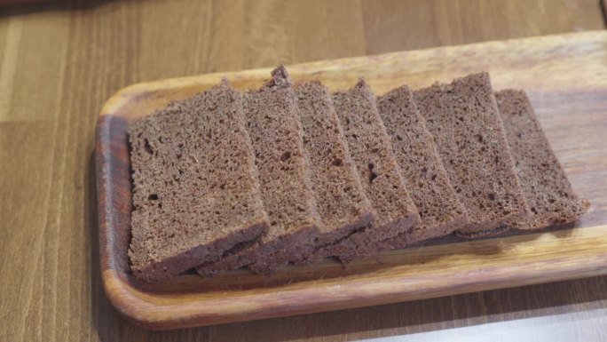 切好的黑面包片放在长方形的木盘上。