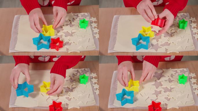 女孩的手在生面团上刻出图形，在木桌上做饼干。大小不一的星星，圣诞饼干。正面特写