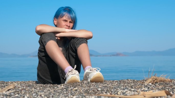 有压力的蓝头发少年在岸上。
