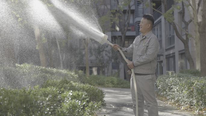 小区 园林绿化 保洁人员在阳光下浇水