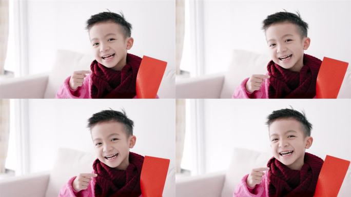 快乐的亚洲男孩展示并拿着红包。快乐的中国新年概念。