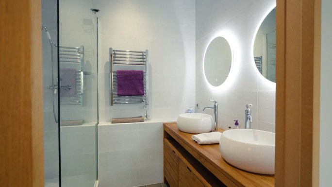 现代设计的2人浴室，镜子后面的led灯和木盆。