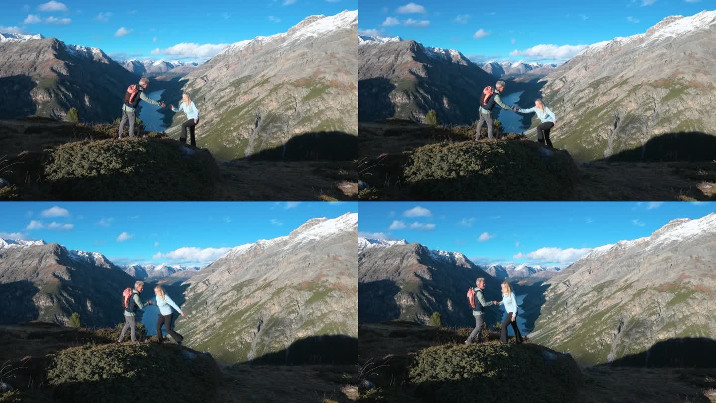 成熟的徒步夫妇穿越高山山腰，秋天