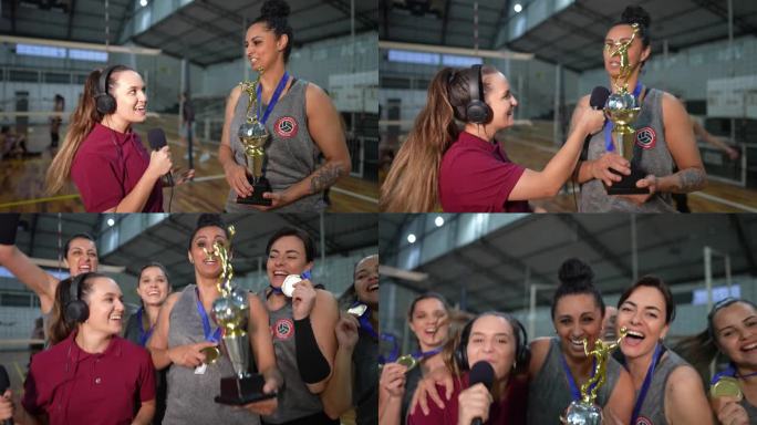 年轻的女电视记者在体育场上采访赢得比赛后的女排——镜头的视角