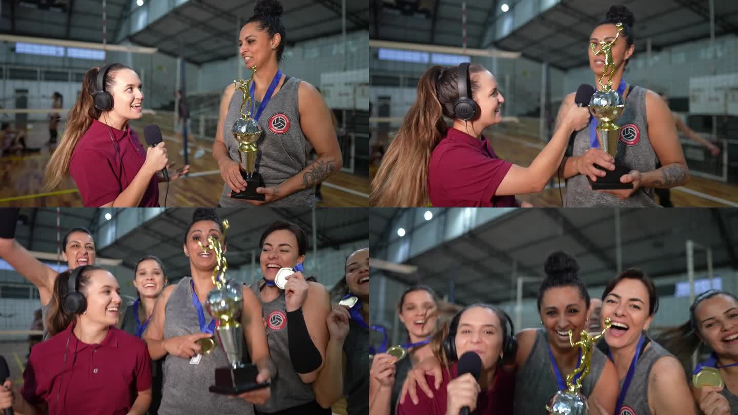 年轻的女电视记者在体育场上采访赢得比赛后的女排——镜头的视角