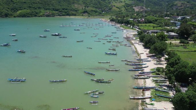 在一个炎热的夏日午后，印度尼西亚龙目岛的海岸上，清澈的海水和多艘船只。天线。