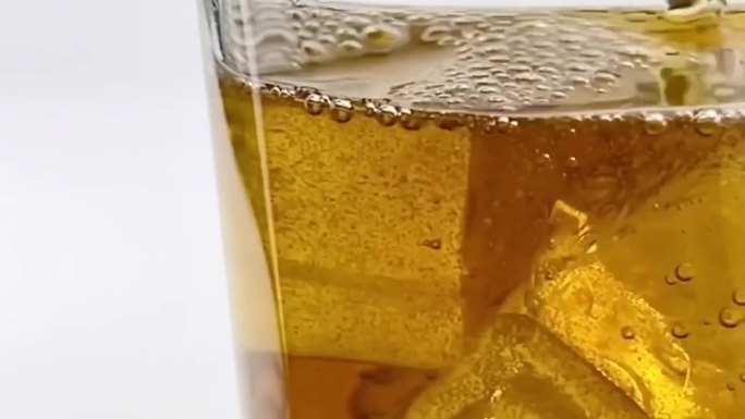 近距离倒软饮料，柠檬茶，柠檬水与冰倒入玻璃杯孤立的白色背景剪辑路径