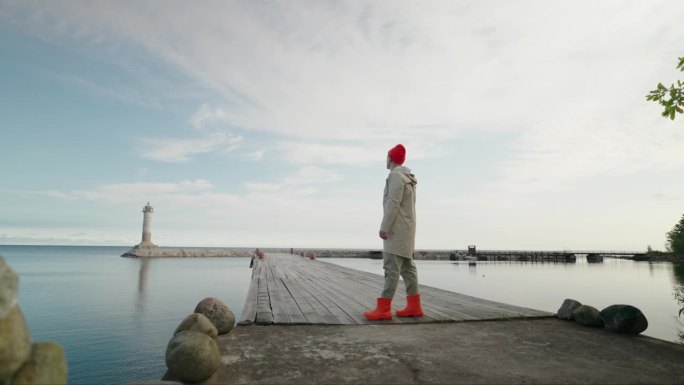清晨，穿着胶靴的孤独渔夫独自站在海湾的旧木码头上