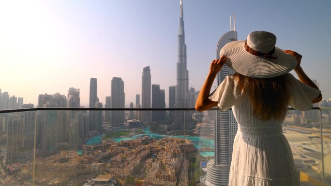 一名女游客正在观看迪拜市区天际线的日落景色
