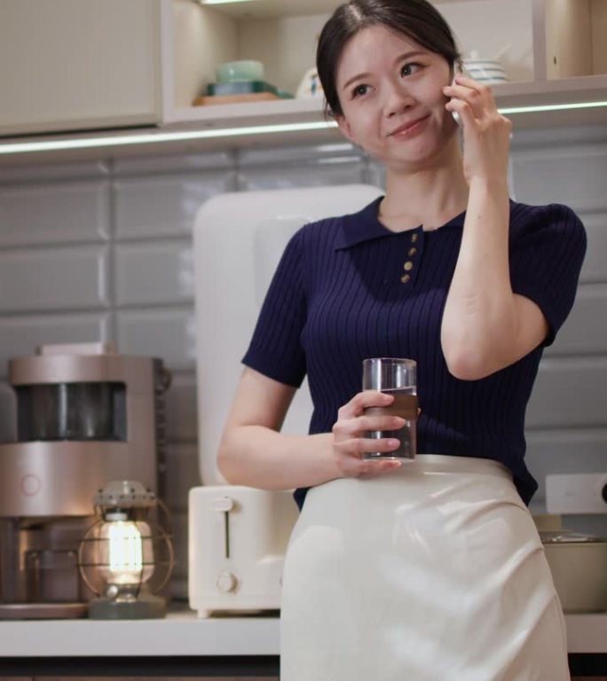 年轻的亚洲女设计师正在餐厅打电话工作