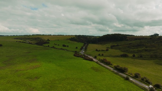 英国萨默塞特郡，无人机拍摄的乡村公路穿过广阔的绿色门迪普山。