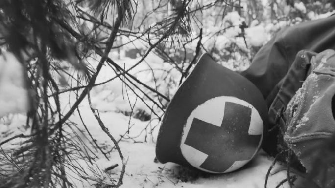 第二次世界大战中美国步兵医疗兵的金属头盔。医护兵头盔躺在阵亡士兵附近。演员在冬天装扮成美国军医。二战