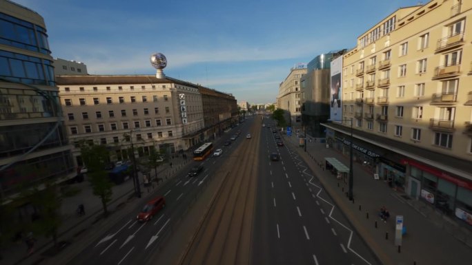在现代城市华沙，无人机在繁忙的街道上穿行，街道上有汽车和有轨电车。现代建筑