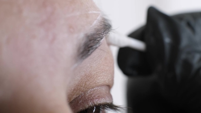 一位女性客户在接受永久性美容治疗前接受专家眉毛测绘的微距照片