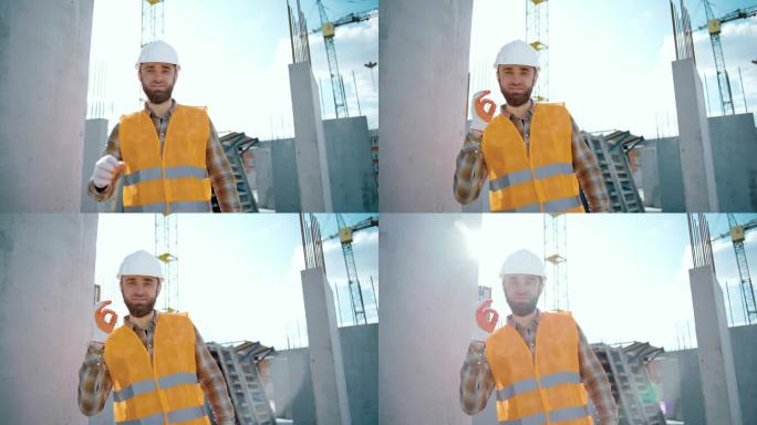 白人技术承包商戴着安全帽，在工地上做着ok的手势。推荐ok标识厂工作