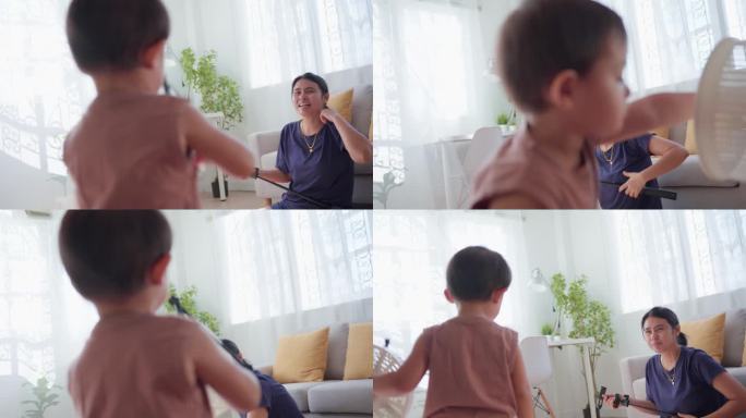 妈妈和小男孩在家里的客厅里玩耍、跳舞、唱歌。