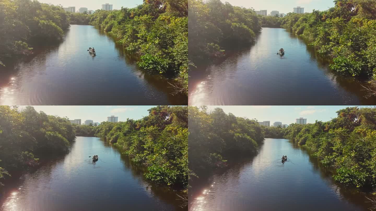 无人机拍摄的一个人划着独木舟顺流而下的画面