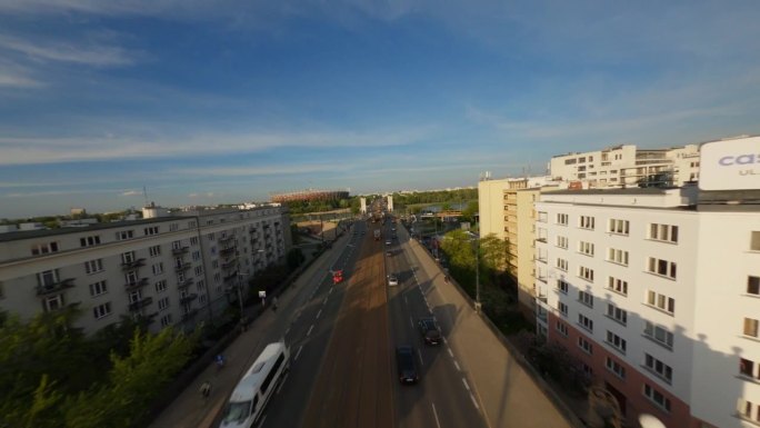 在现代城市华沙，无人机在繁忙的街道上穿行，街道上有汽车和有轨电车。维斯瓦河上的桥