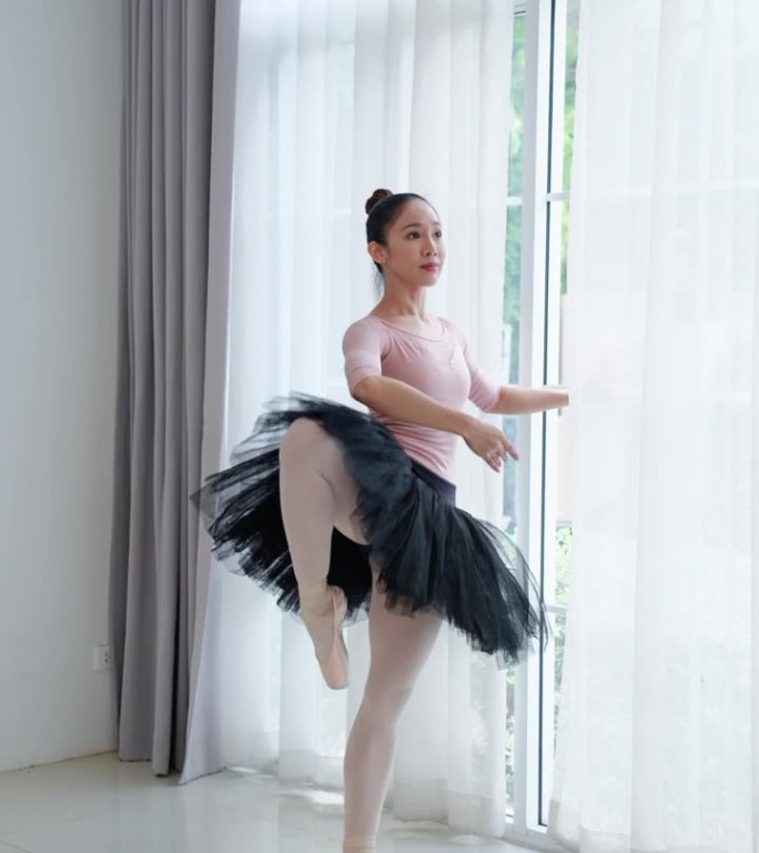 迷人的年轻女子在精致的粉红色服装旋转和摆姿势在舞蹈工作室表演艺术活动的亚洲女舞者喜欢磨练她的芭蕾舞步