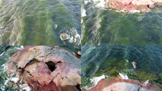 一个浅湖的航拍照片，下面有沉积物和一个小岩石岛