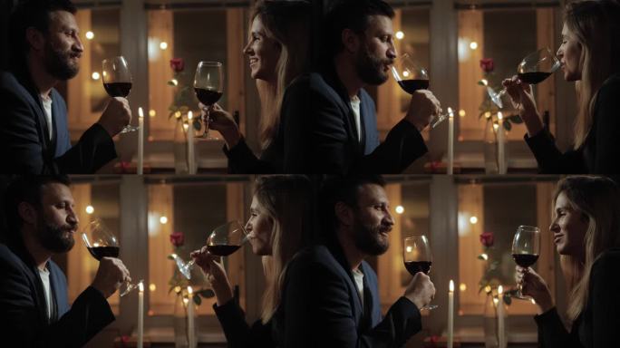 约会，情人节，干杯。男人和女人在浪漫的烛光下聊天，喝红酒