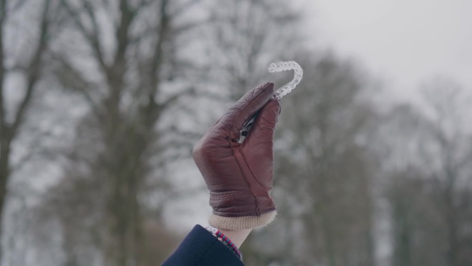 皮革手套展示了一个明确的牙齿调节校准器，冬天的一天，近距离