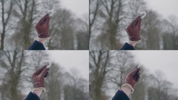 皮革手套展示了一个明确的牙齿调节校准器，冬天的一天，近距离