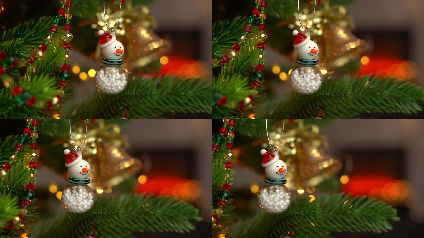 圣诞树上的白色雪人和壁炉背景上的金色铃铛