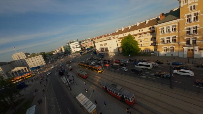在现代城市华沙，无人机在繁忙的街道上穿行，街道上有汽车和有轨电车。历史悠久的老教堂
