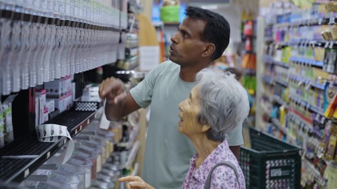 一位老妇人在家庭看护的帮助下购物